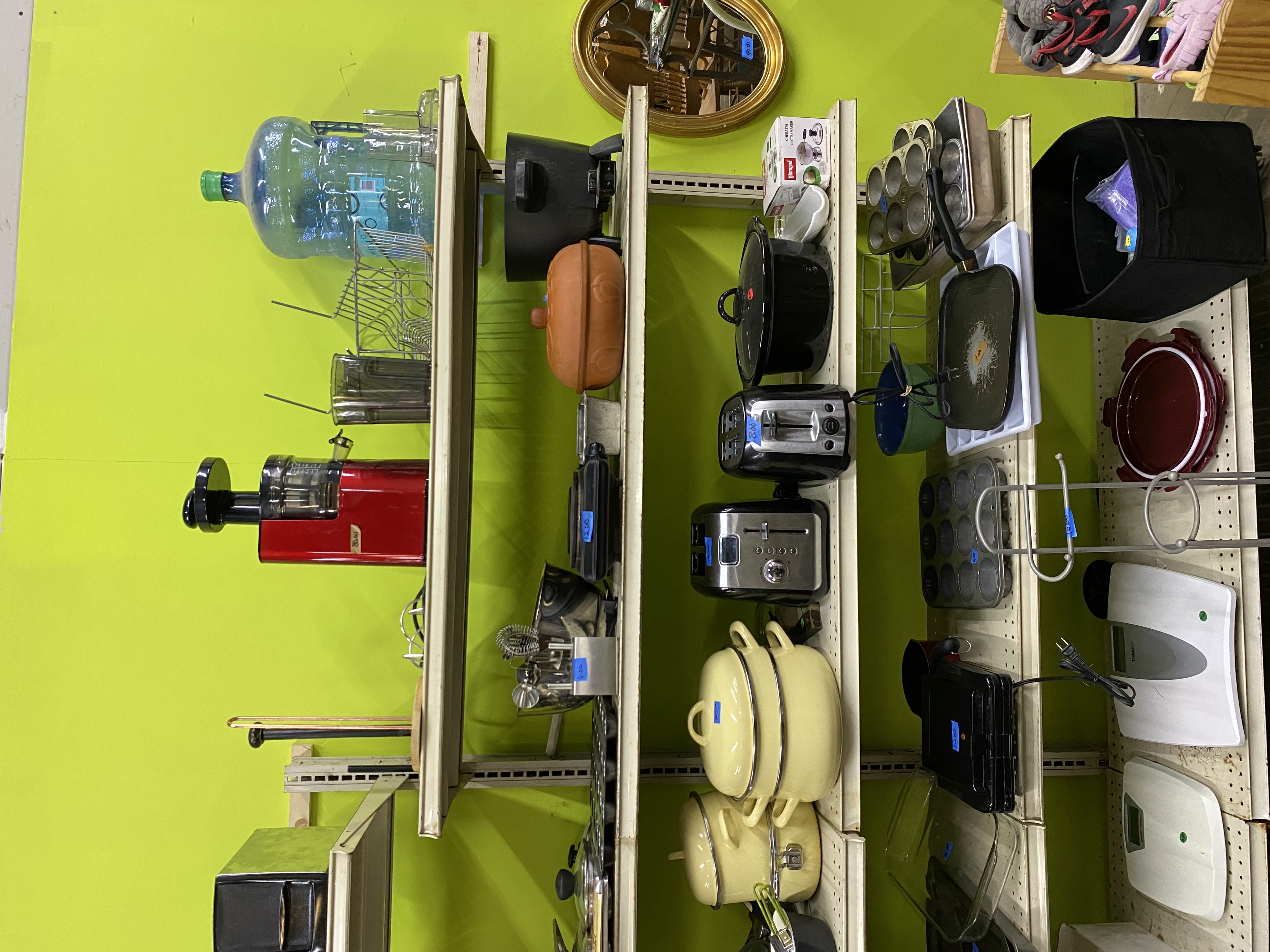 Assorted small appliances and electronics on thrift store shelves