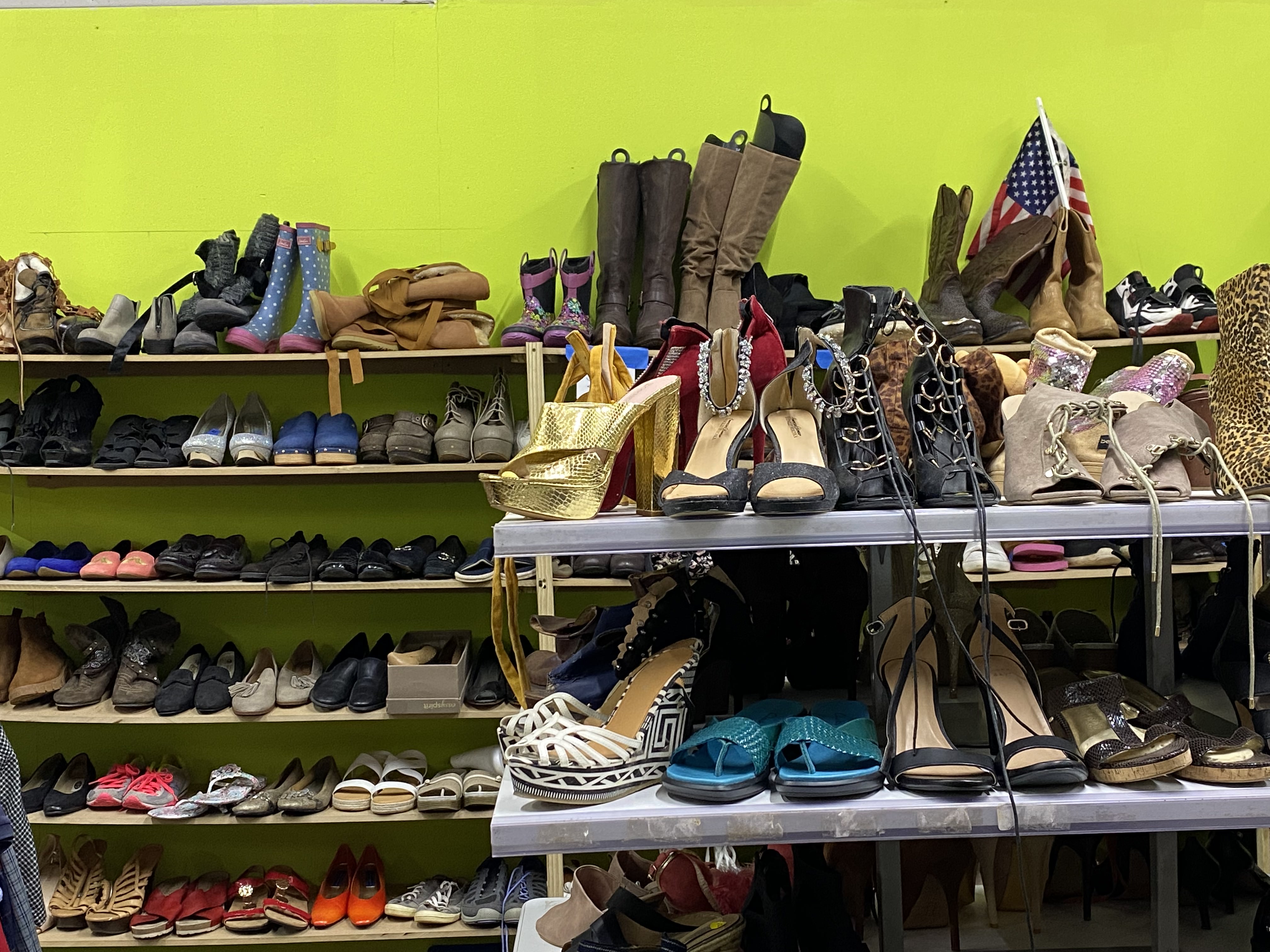 Thrift store shoe selection displayed neatly on racks